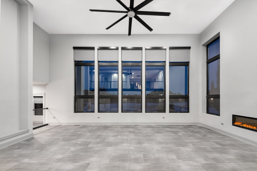 Geräumiges, Offenes Modernes Wohnzimmer mit grauer Wandfarbe, Gaskamin, grauem Boden und gewölbter Decke in Chicago