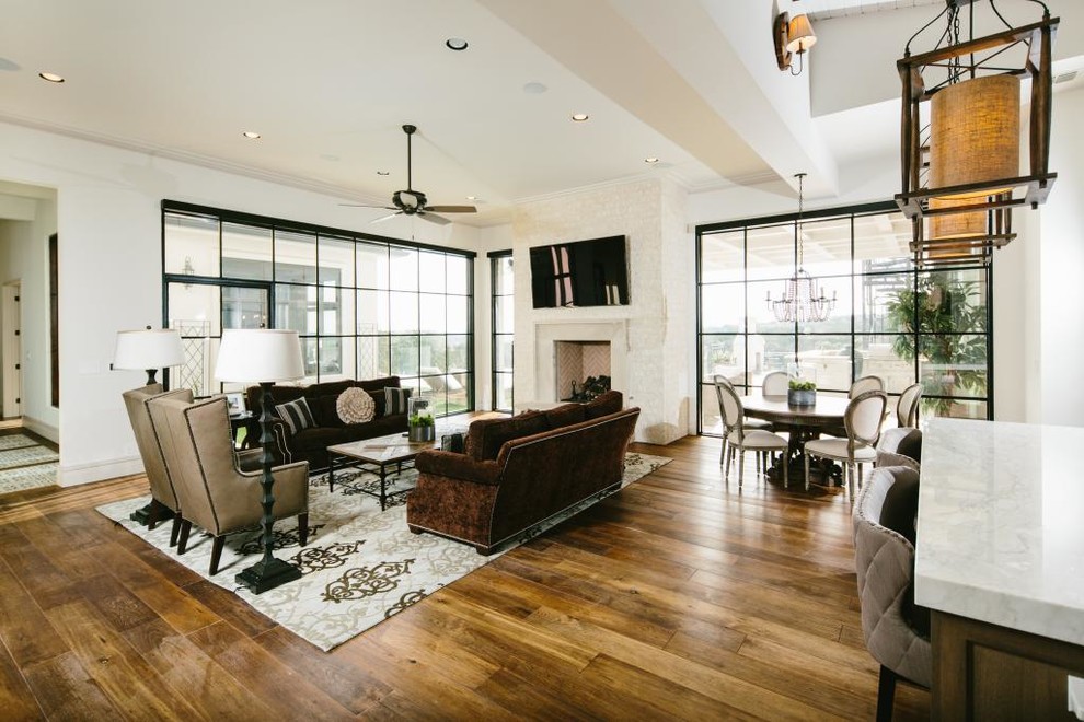 Photo of a classic enclosed games room in Austin with white walls, medium hardwood flooring, a standard fireplace, a wall mounted tv and a plastered fireplace surround.