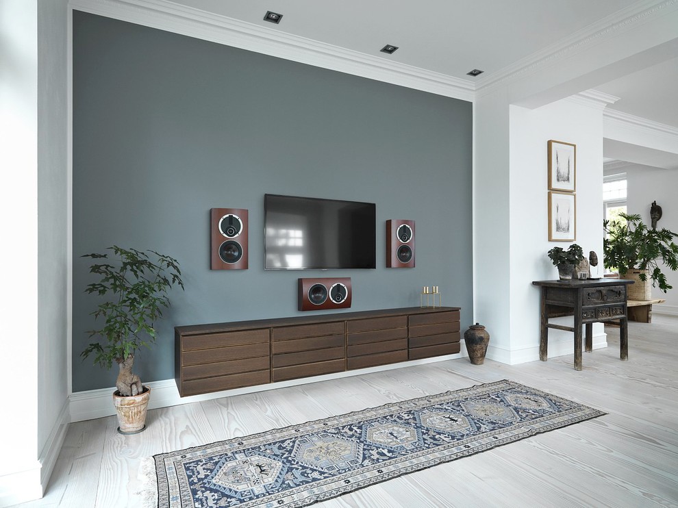 Imagen de sala de estar abierta tradicional de tamaño medio sin chimenea con suelo de madera clara, televisor colgado en la pared y paredes grises