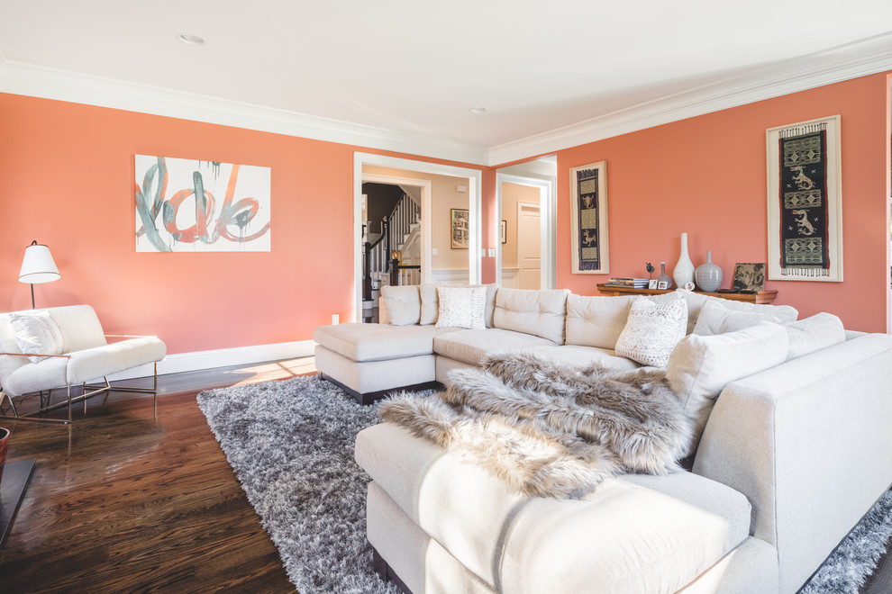 На фото: изолированная гостиная комната среднего размера в классическом стиле с оранжевыми стенами, темным паркетным полом, стандартным камином, фасадом камина из бетона, телевизором на стене и коричневым полом