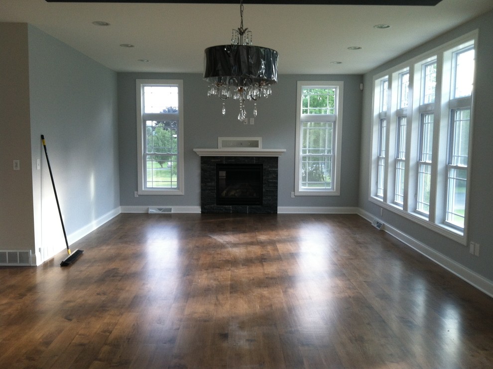 Foto de sala de estar abierta moderna de tamaño medio con paredes grises, suelo de madera en tonos medios y todas las chimeneas