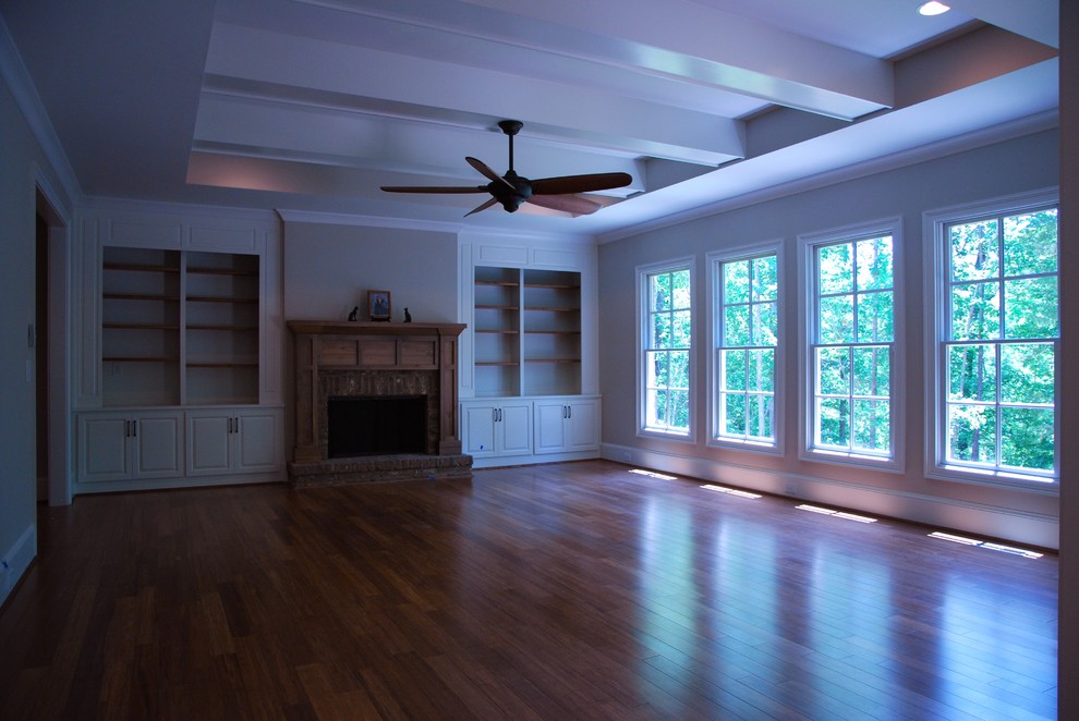 Großes, Offenes Klassisches Wohnzimmer mit beiger Wandfarbe, braunem Holzboden, Kamin und Kaminumrandung aus Holz in Atlanta