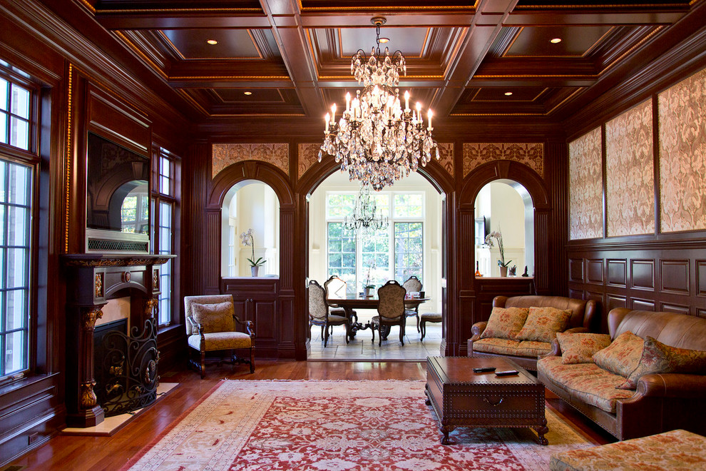 Example of a classic medium tone wood floor and brown floor living room design in New York with brown walls, a standard fireplace and a wall-mounted tv