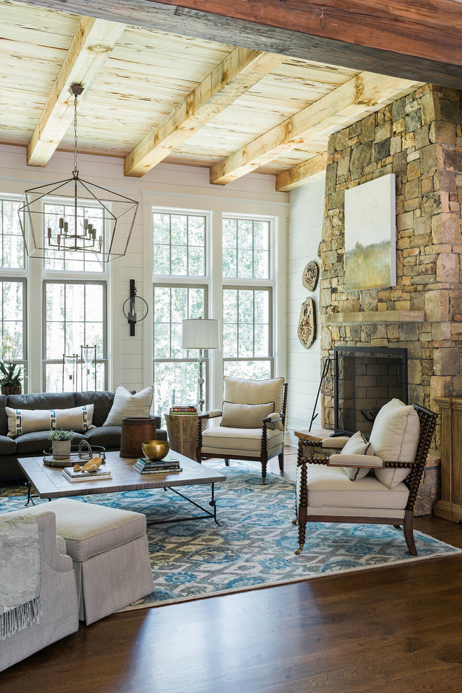 Example of a mid-sized farmhouse enclosed dark wood floor and brown floor family room design in Atlanta with white walls, a standard fireplace, a stone fireplace and no tv