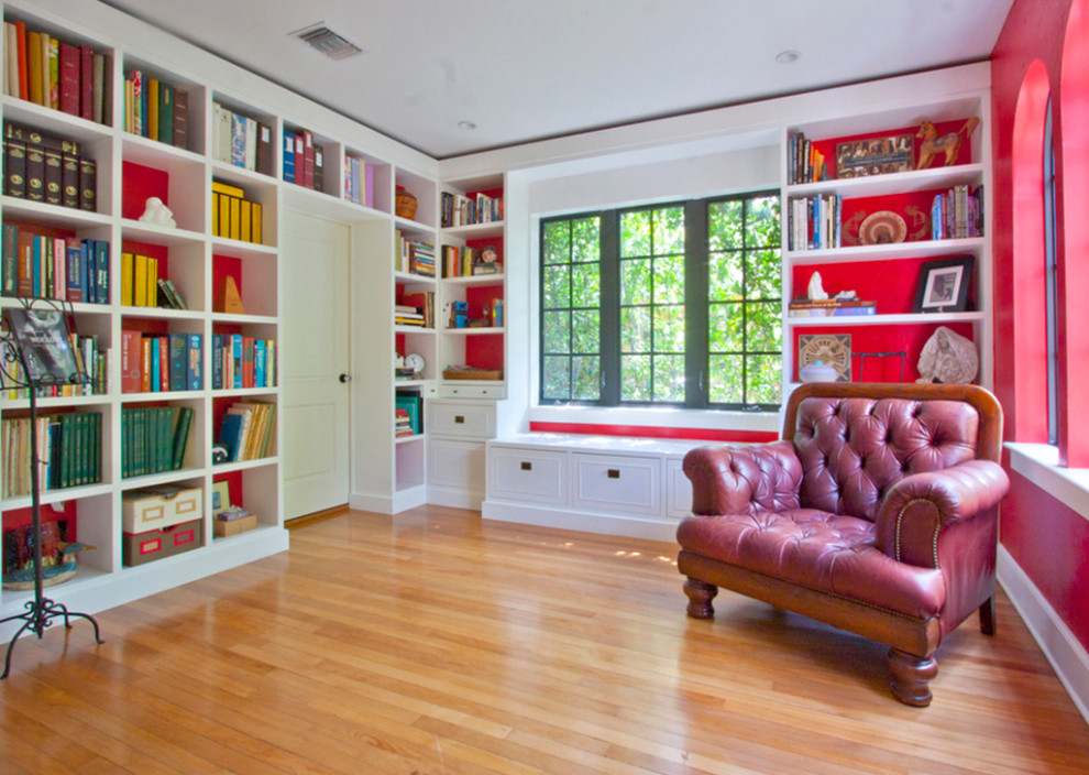 Immagine di un grande soggiorno minimal aperto con libreria, pareti rosse, parquet chiaro, nessun camino, nessuna TV e pavimento arancione