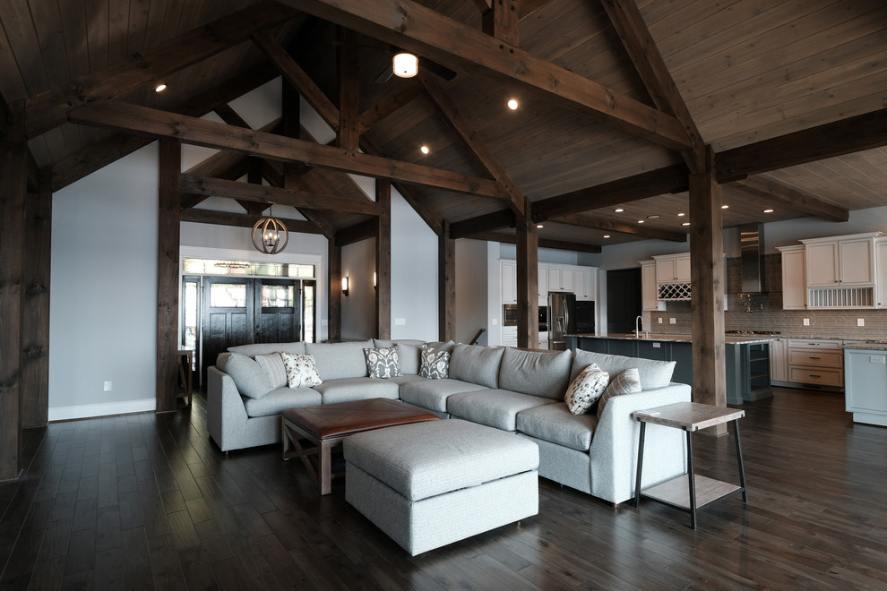 This is an example of a large rustic open plan games room in DC Metro with grey walls, dark hardwood flooring, a ribbon fireplace, a stone fireplace surround and brown floors.