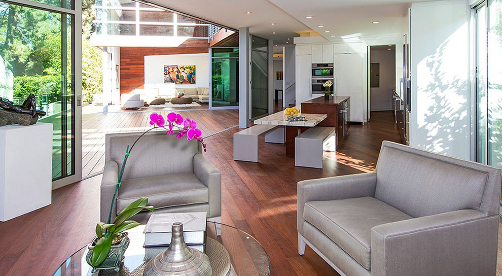 This is an example of a contemporary open plan games room in Los Angeles with white walls and dark hardwood flooring.