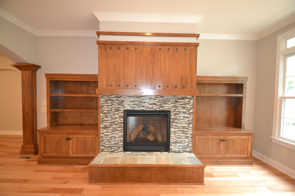 Aménagement d'une salle de séjour craftsman avec une cheminée standard, un manteau de cheminée en carrelage et un téléviseur encastré.