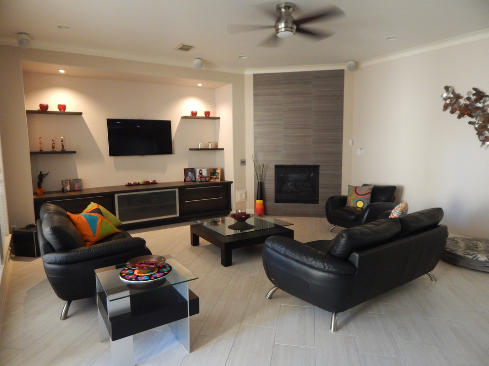 Diseño de sala de estar abierta contemporánea de tamaño medio sin chimenea con paredes beige, suelo de baldosas de porcelana, televisor colgado en la pared y suelo marrón