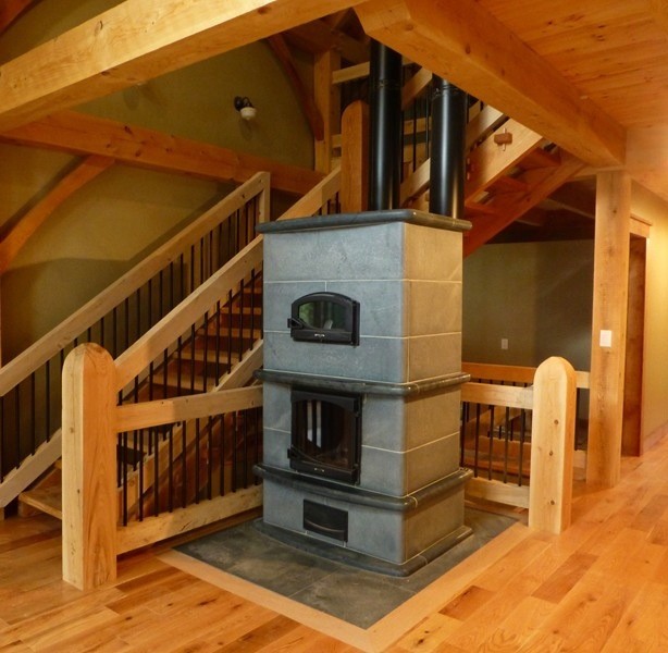 Diseño de sala de estar de estilo de casa de campo con suelo de madera clara y marco de chimenea de piedra