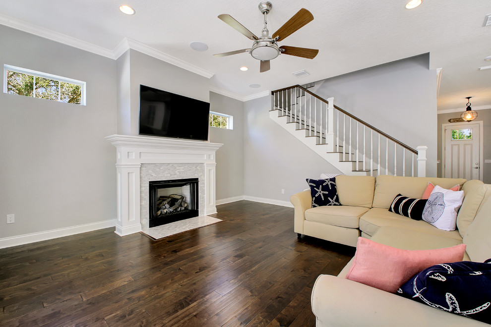 Inspiration for a medium sized coastal open plan games room in Tampa with grey walls, dark hardwood flooring, a standard fireplace, a tiled fireplace surround and a wall mounted tv.