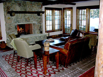 Bild på ett stort rustikt allrum med öppen planlösning, med ett spelrum, beige väggar, mörkt trägolv, en standard öppen spis, en spiselkrans i sten och en inbyggd mediavägg