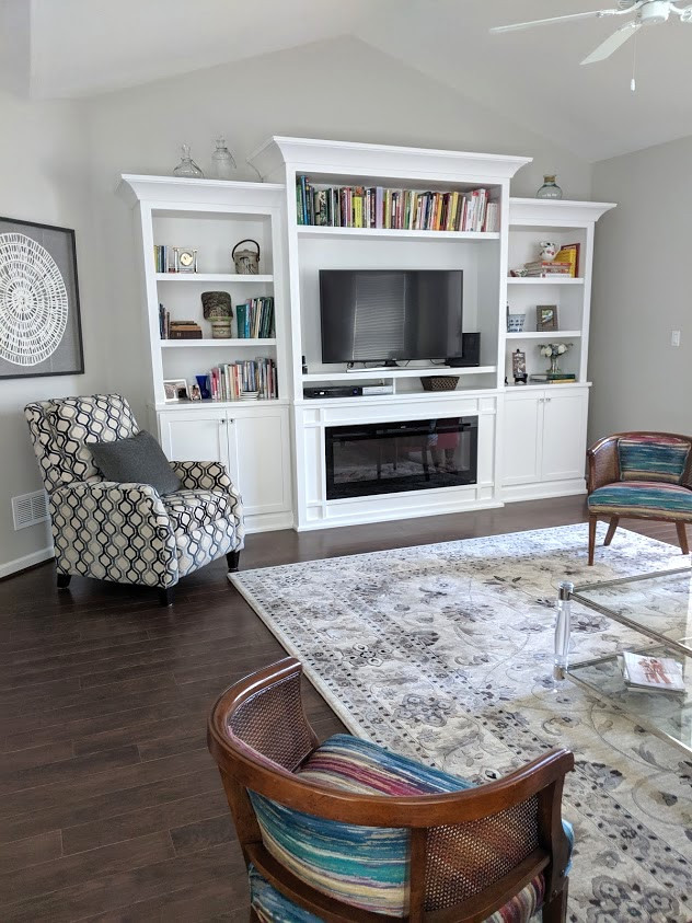 Photo of a medium sized classic enclosed games room in Other with grey walls, dark hardwood flooring, a ribbon fireplace, a wooden fireplace surround, a built-in media unit and brown floors.
