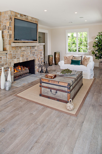 Large elegant open concept light wood floor and beige floor family room photo in Orange County with beige walls, a standard fireplace, a stone fireplace and a wall-mounted tv