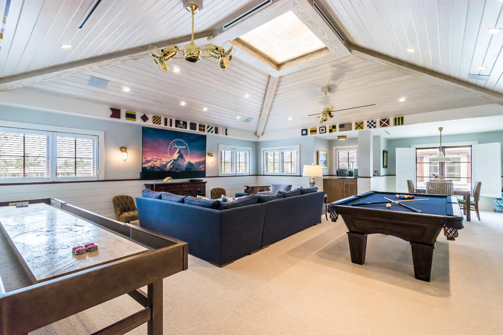 Esempio di un soggiorno tropicale con sala giochi, pareti blu, moquette, TV a parete e pavimento beige