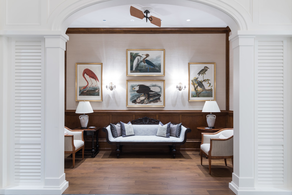 Imagen de sala de estar tropical con paredes beige, suelo de madera en tonos medios y suelo marrón