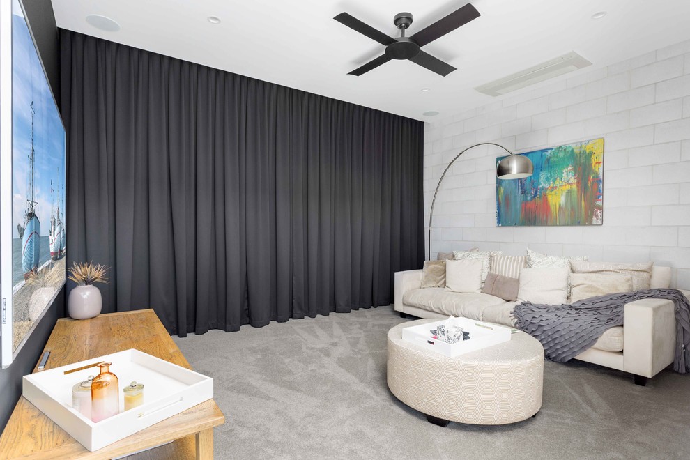 Foto på ett funkis avskilt allrum, med grå väggar, heltäckningsmatta, grått golv och en väggmonterad TV