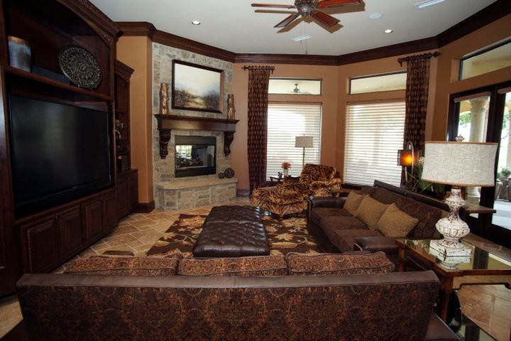 Inspiration for a large transitional enclosed carpeted family room remodel in Atlanta with beige walls, a standard fireplace, a stone fireplace and a media wall