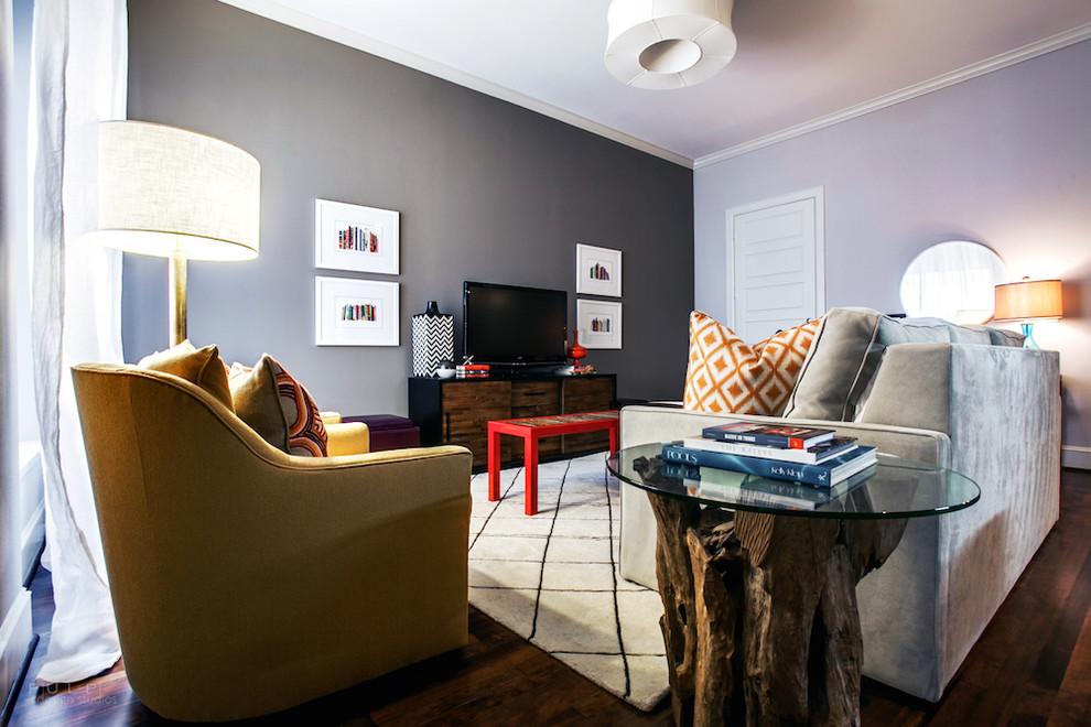 Ejemplo de sala de estar abierta actual de tamaño medio sin chimenea con paredes grises, suelo de madera oscura y televisor independiente