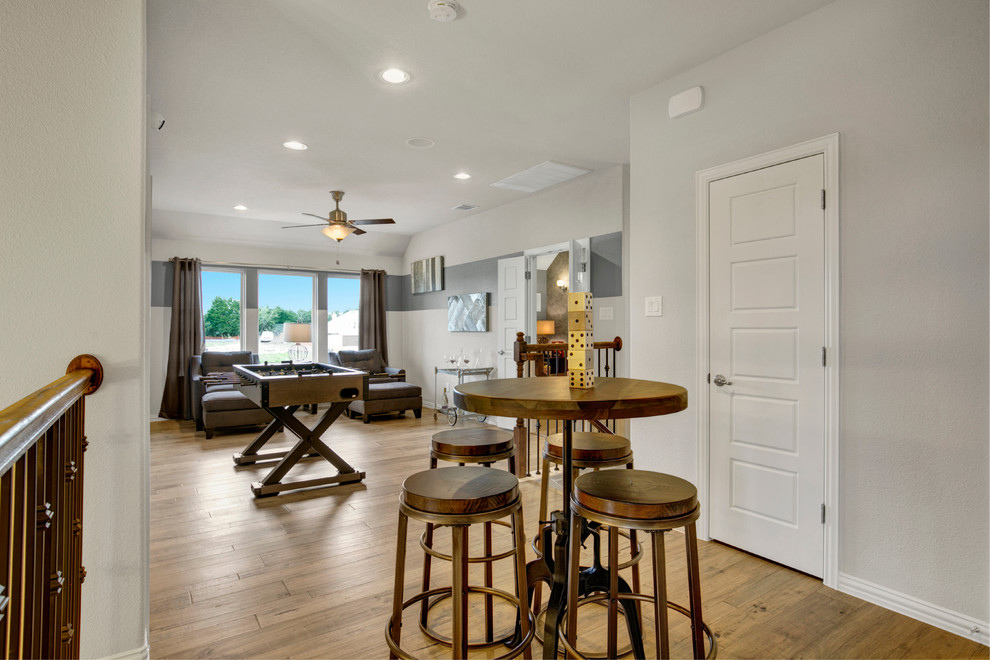 Large transitional loft-style medium tone wood floor and brown floor game room photo in Dallas with gray walls