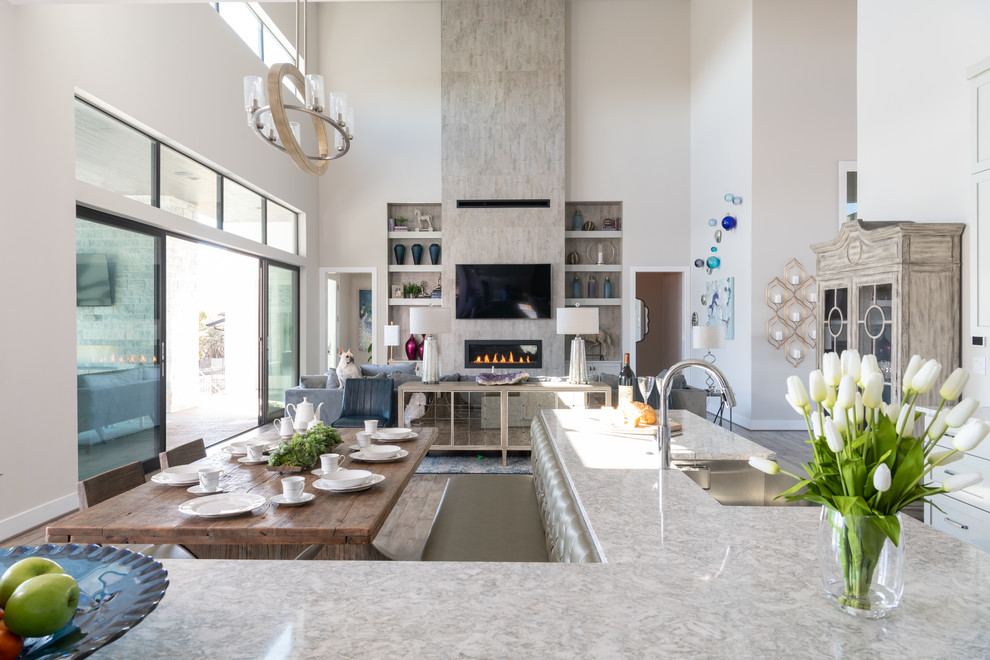 Großes, Offenes Modernes Wohnzimmer mit weißer Wandfarbe, braunem Holzboden, Gaskamin, gefliester Kaminumrandung, TV-Wand und grauem Boden in Austin