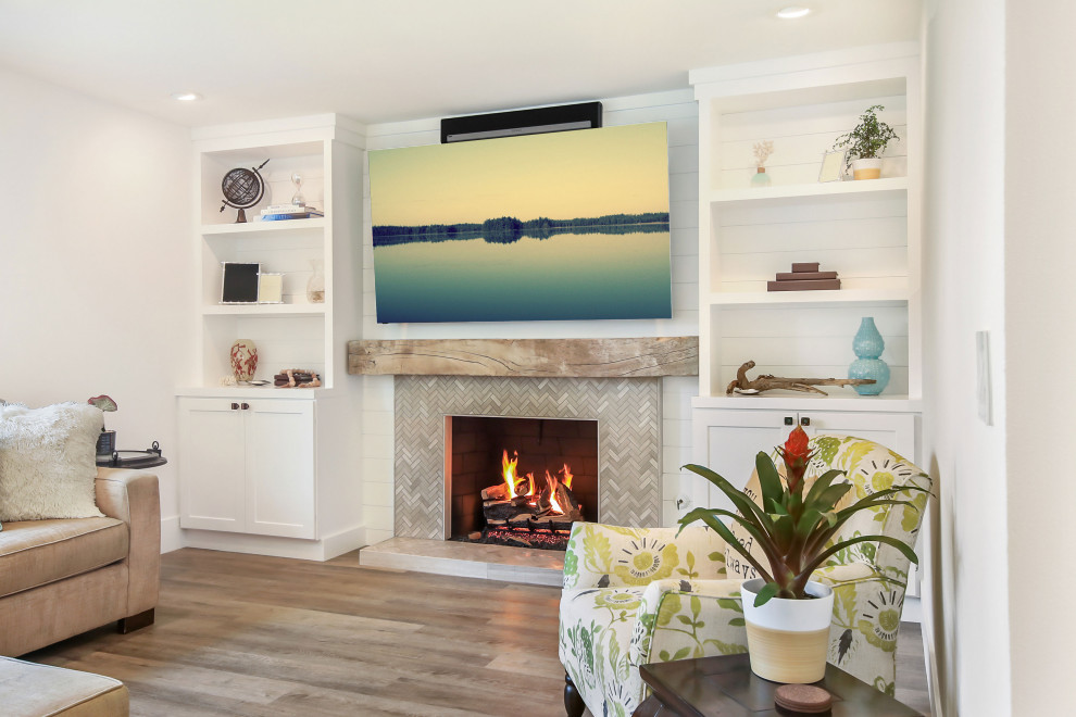 Inspiration for a large cottage open concept medium tone wood floor and brown floor family room remodel in Orange County with white walls, a standard fireplace, a tile fireplace and a wall-mounted tv