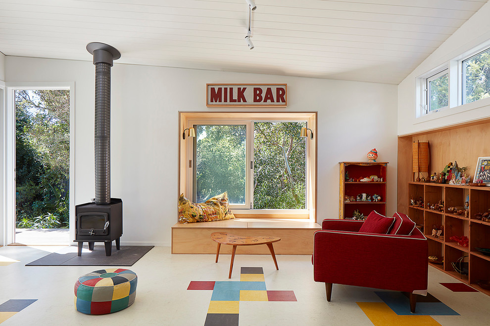 Modelo de sala de estar vintage con paredes blancas, estufa de leña, marco de chimenea de metal y suelo multicolor