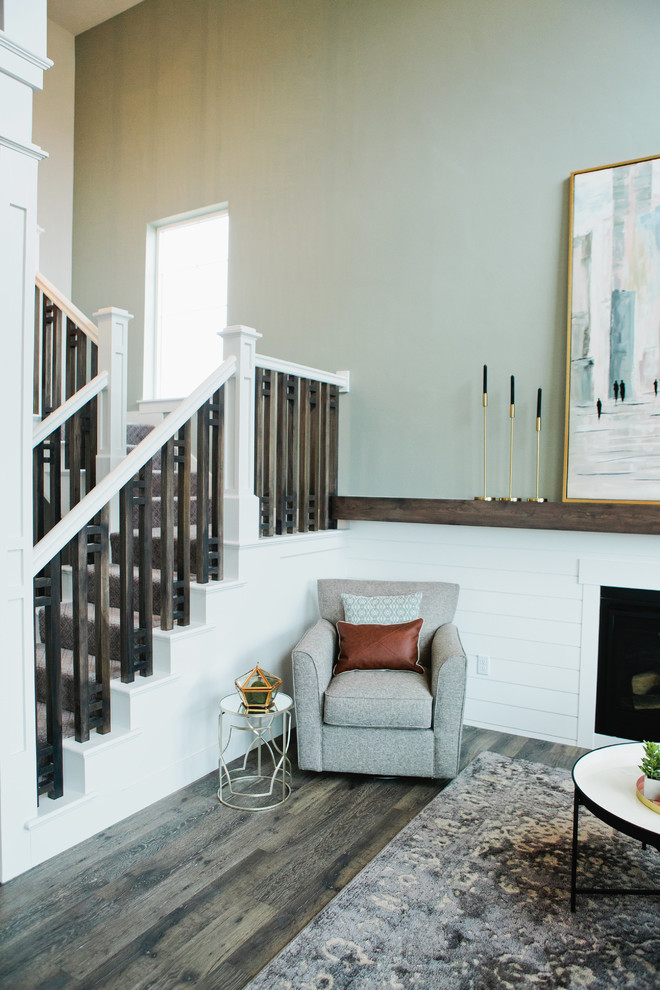 Immagine di un piccolo soggiorno american style stile loft con pareti grigie, pavimento in laminato, camino classico, TV a parete e pavimento grigio