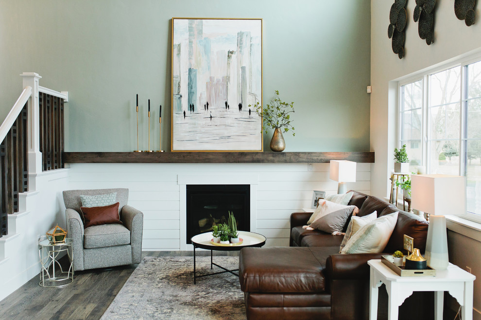 Diseño de sala de estar tipo loft de estilo americano pequeña con paredes grises, suelo laminado, todas las chimeneas, televisor colgado en la pared, suelo gris y alfombra