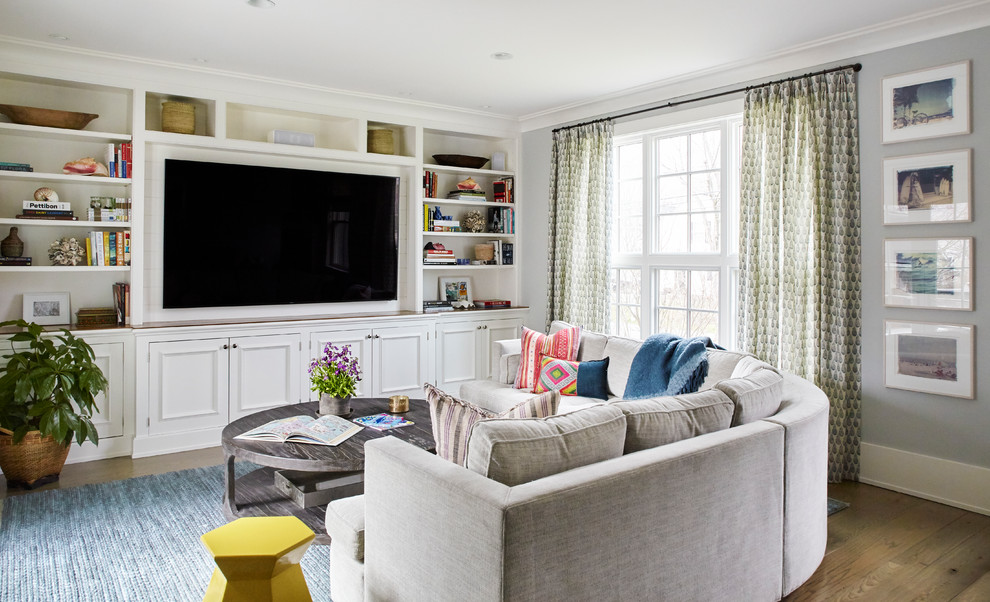 Ejemplo de sala de estar con biblioteca abierta tradicional con paredes azules y televisor colgado en la pared