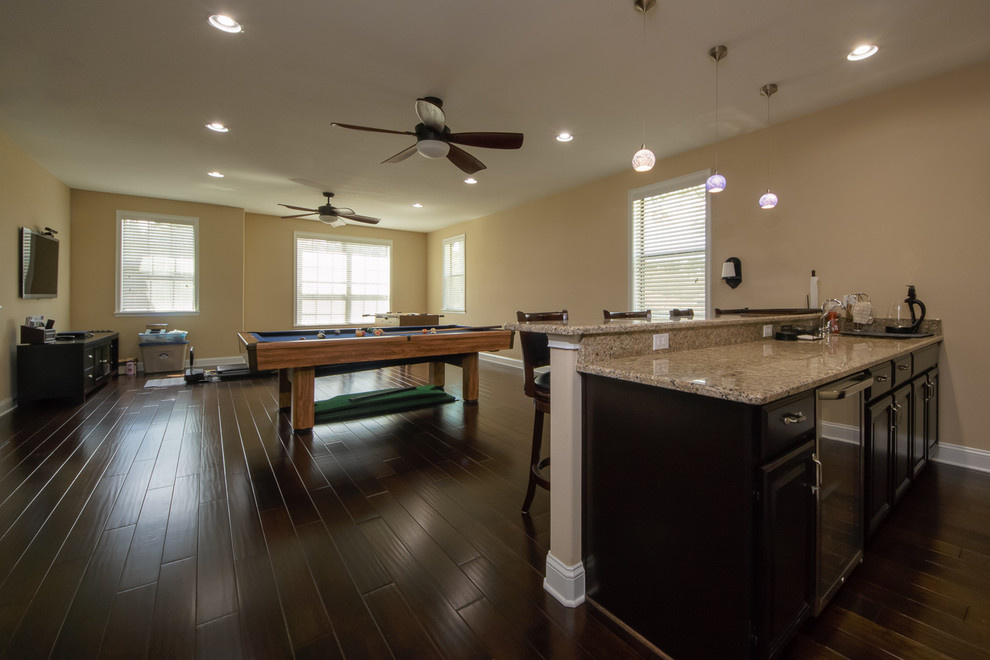Large classic open plan games room in Orlando with dark hardwood flooring, a wall mounted tv and a game room.