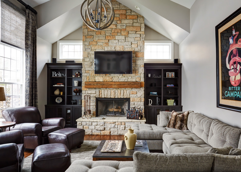 Family room - mid-sized transitional open concept medium tone wood floor family room idea in Chicago with gray walls, a standard fireplace, a stone fireplace and a wall-mounted tv