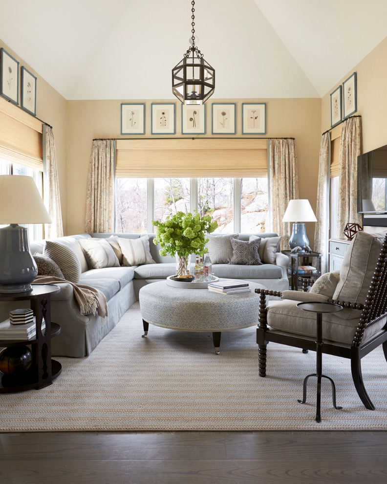 Elegant dark wood floor and brown floor family room photo in Boston with beige walls and a wall-mounted tv