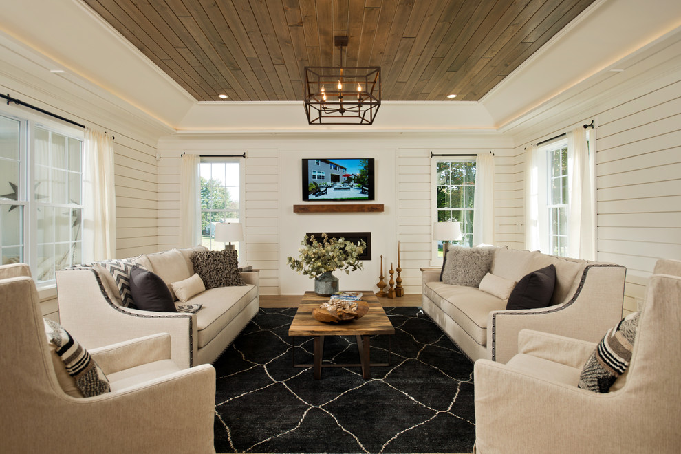 На фото: гостиная комната в стиле кантри с белыми стенами, паркетным полом среднего тона, горизонтальным камином, телевизором на стене и ковром на полу с