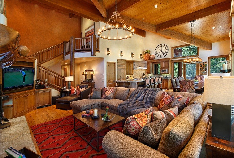 Family room - huge southwestern open concept medium tone wood floor family room idea in Salt Lake City with orange walls, a standard fireplace, a stone fireplace and a media wall