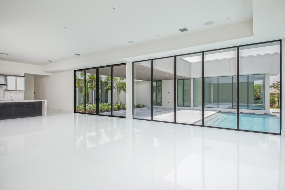 Inspiration for a large modern open plan games room in Miami with white walls, no fireplace and white floors.