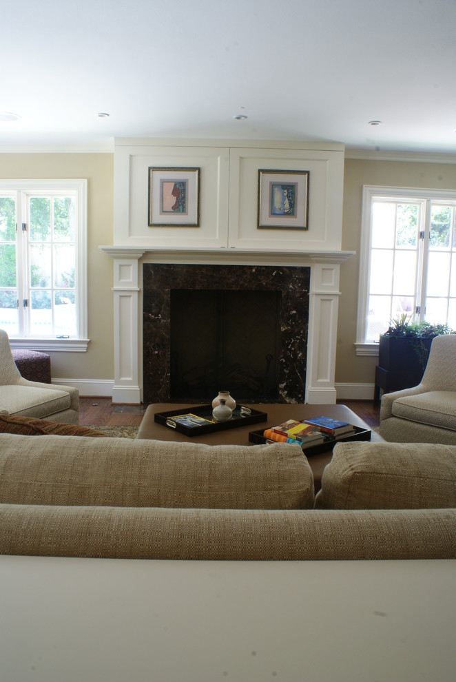 Example of a mid-sized classic open concept medium tone wood floor family room design in Dallas with beige walls, a standard fireplace, a wood fireplace surround and a concealed tv
