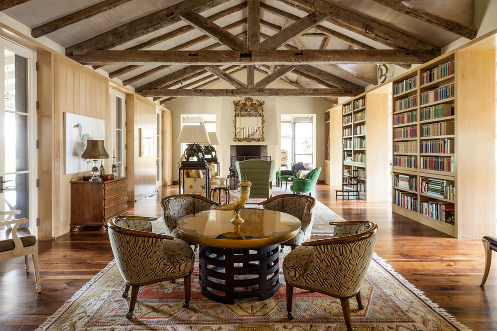 Foto de sala de estar con biblioteca abierta, mediterránea, con paredes beige y suelo de madera oscura