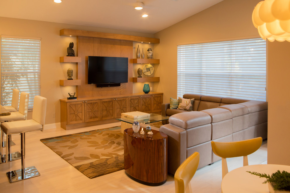 Esempio di un soggiorno design aperto e di medie dimensioni con pareti beige, parquet chiaro, parete attrezzata, pavimento beige e nessun camino
