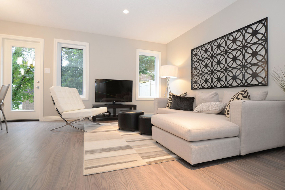 Ejemplo de sala de estar abierta contemporánea pequeña con paredes grises, suelo de madera clara y alfombra