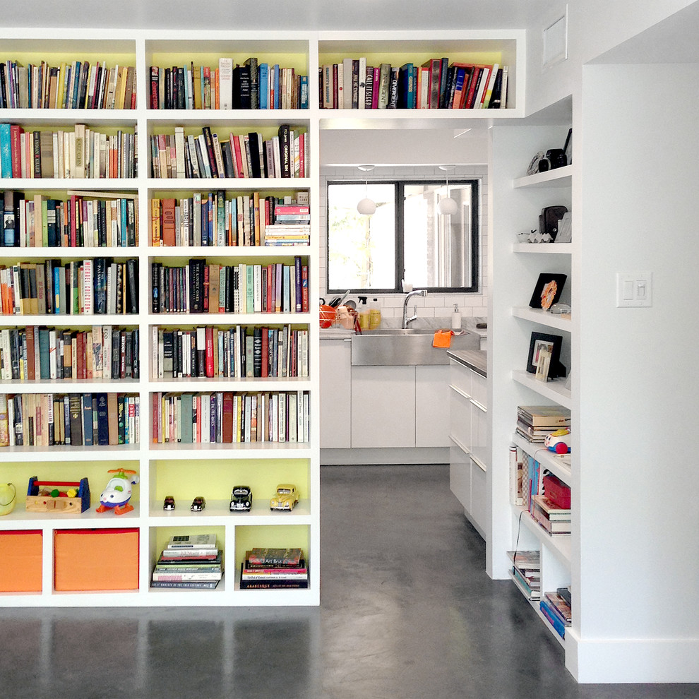 Inspiration for a large contemporary enclosed concrete floor and gray floor family room library remodel in Houston with white walls, no fireplace and no tv