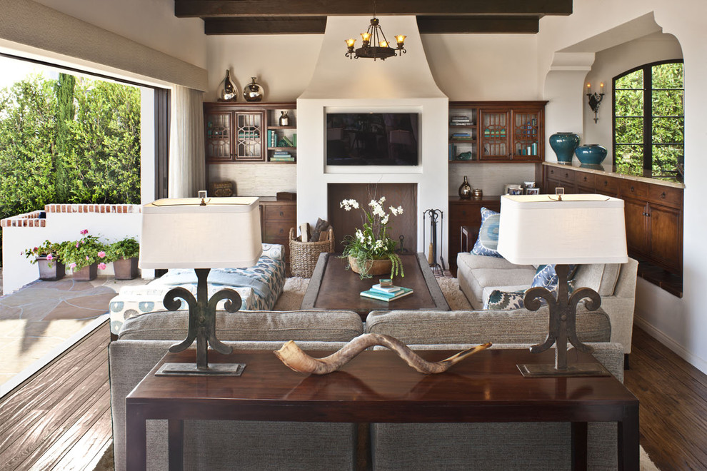 Inspiration for a mid-sized mediterranean open concept dark wood floor and brown floor family room remodel in Los Angeles with beige walls, a wall-mounted tv and no fireplace