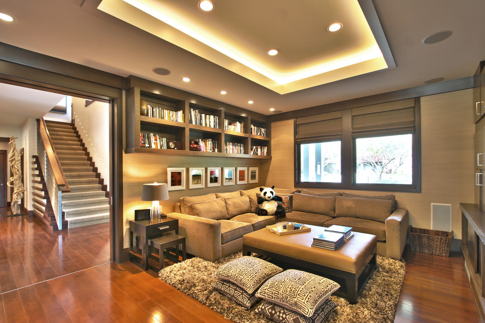 Example of a trendy medium tone wood floor family room design in Los Angeles with beige walls