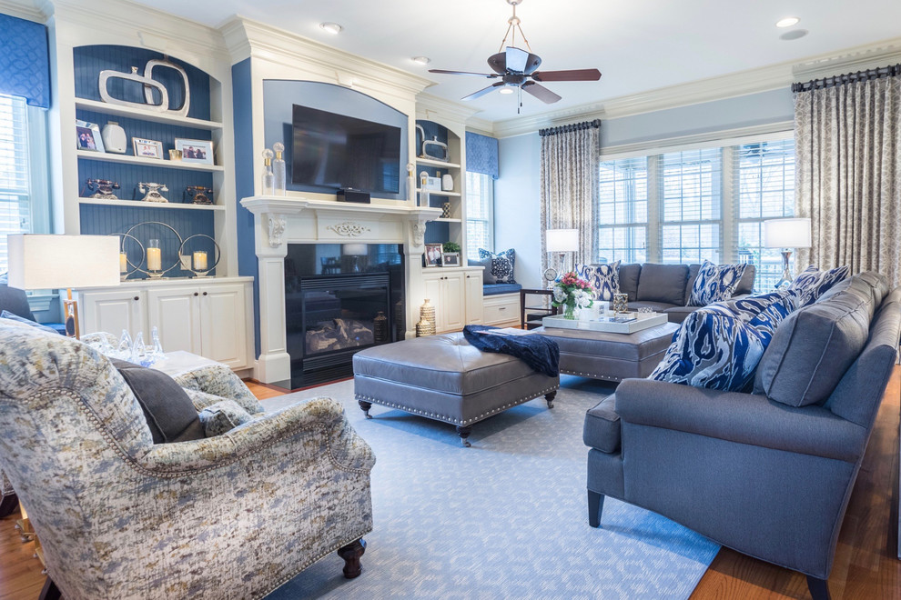 Large transitional open concept medium tone wood floor and brown floor family room photo in Raleigh with blue walls, a standard fireplace, a tile fireplace and a wall-mounted tv