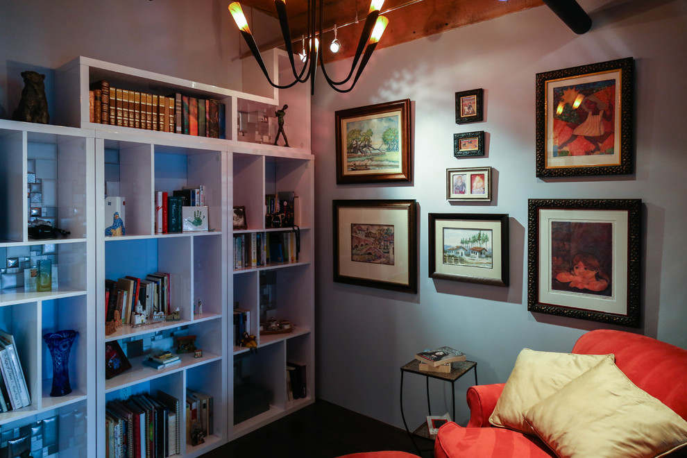 Cette image montre une petite salle de séjour design fermée avec une bibliothèque ou un coin lecture, un mur blanc, parquet foncé et aucun téléviseur.