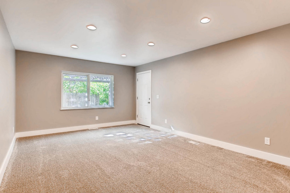 Imagen de sala de estar cerrada actual con paredes grises, moqueta, televisor colgado en la pared y suelo gris