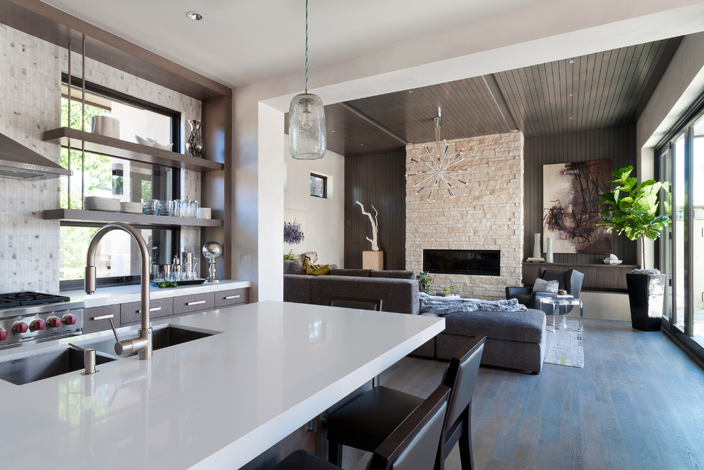 Diseño de sala de estar abierta contemporánea de tamaño medio con suelo de madera en tonos medios, paredes grises, marco de chimenea de piedra y suelo gris