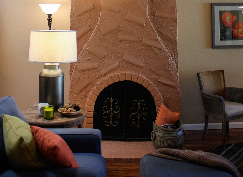 Exemple d'une salle de séjour sud-ouest américain de taille moyenne et ouverte avec un mur jaune, un sol en bois brun, une cheminée standard, un manteau de cheminée en plâtre et aucun téléviseur.
