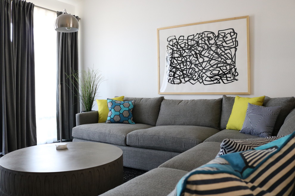 Modelo de sala de estar abierta actual grande sin chimenea y televisor con paredes blancas, moqueta y suelo gris
