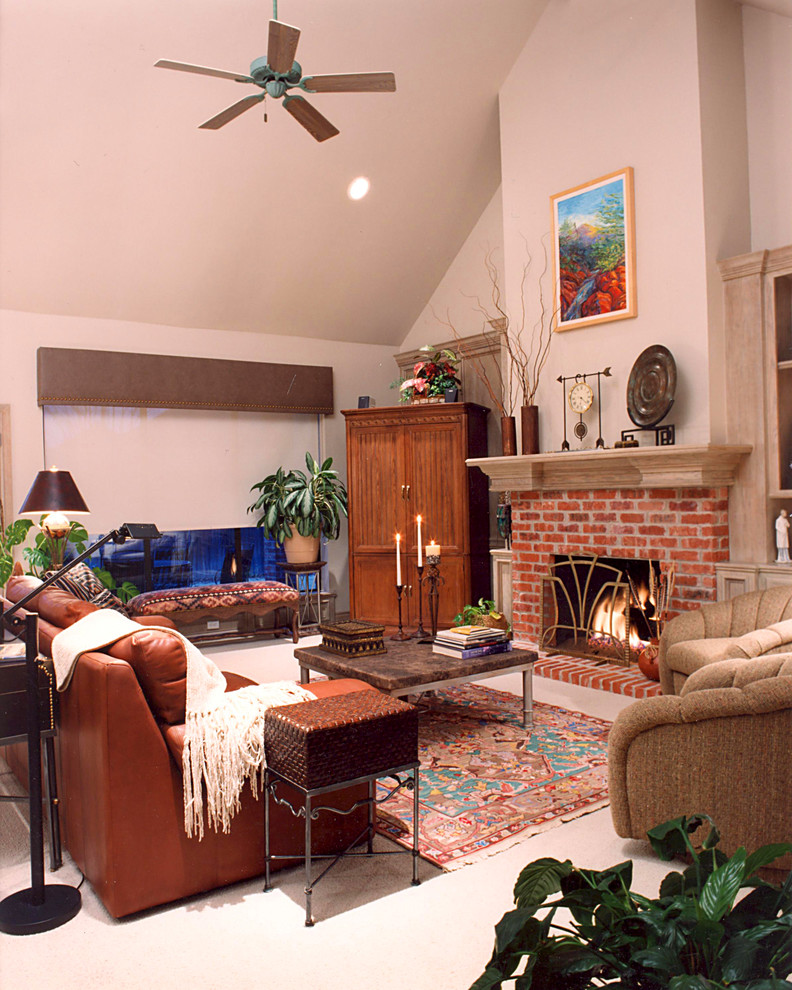 Modelo de sala de estar abierta tradicional de tamaño medio con paredes beige, moqueta, todas las chimeneas, marco de chimenea de ladrillo, televisor retractable y suelo beige